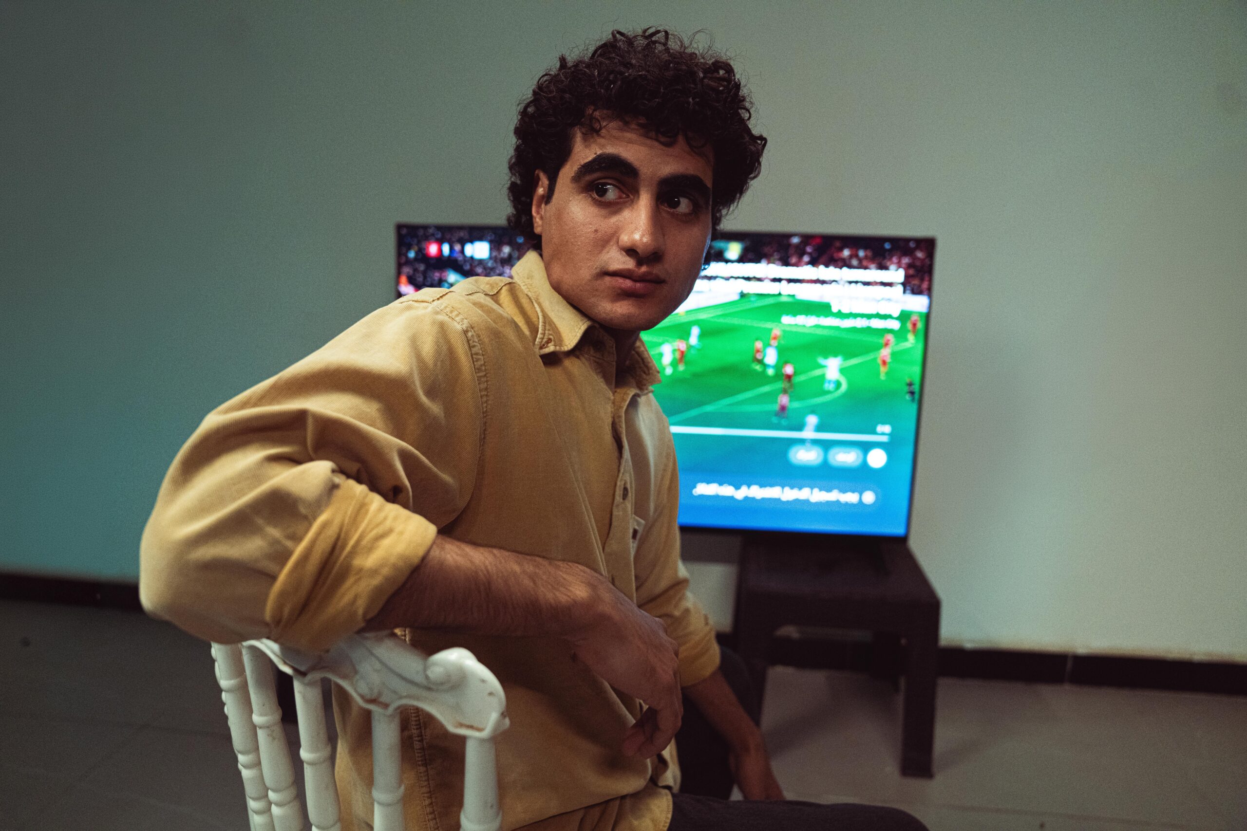 Someone watching sports on a TV looking behind them